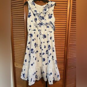 Sleeveless white dress with blue flowers.